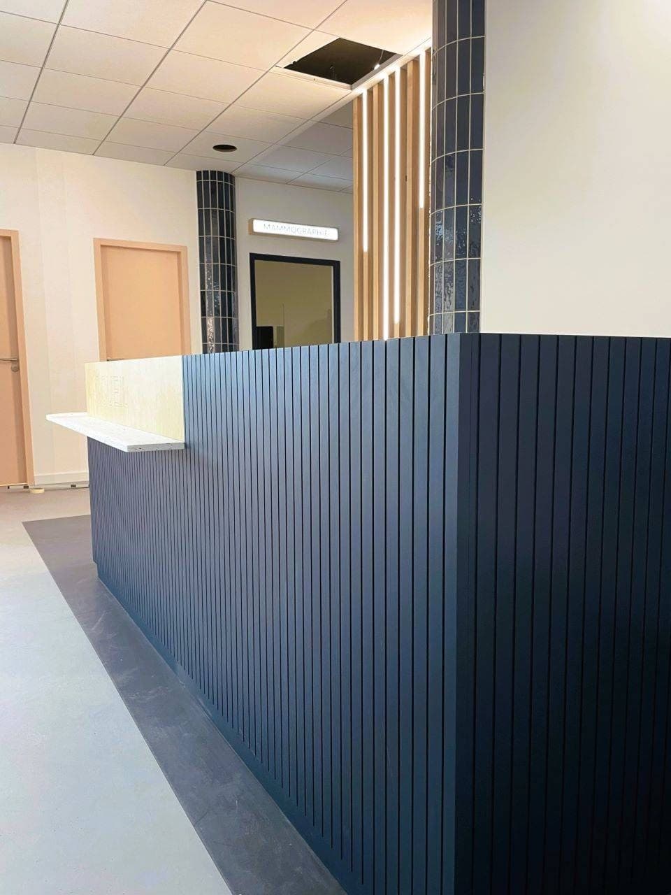 La banque d’accueil vue de côté : medium cintré peint bleu nuit, rainuré