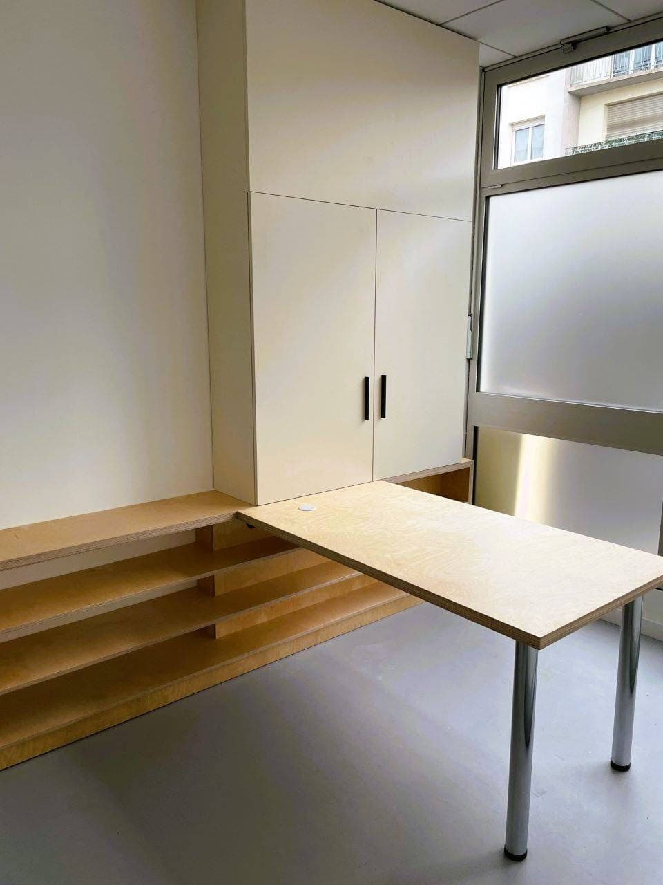 Placards blancs et plan de travail en bois sur mesure dans une salle du cabinet